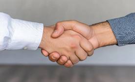 Two men's hands held in a handshake